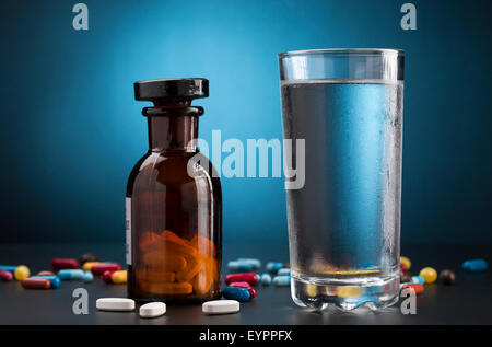 Medicine pills bottle and glass of cold drink water Stock Photo