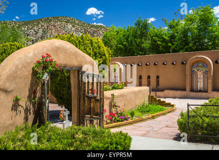 An adobe gate and entrance to the  El Santuario de Chimayó Roman Catholic church in Chimayo, New Mexico, USA Stock Photo