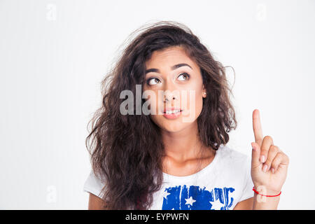 Portrait of a happy teen girl pointing finger up isolated on a white background Stock Photo