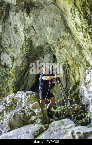 Professional landscape photographer taking shots in a cave Stock Photo