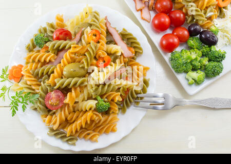 Pasta meal cooked with vegetables with fresh vegetables served in white dishes Stock Photo