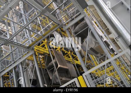 Inside a modern car factory, vehicles and parts move through the production process, car sides hang in storage racks Stock Photo