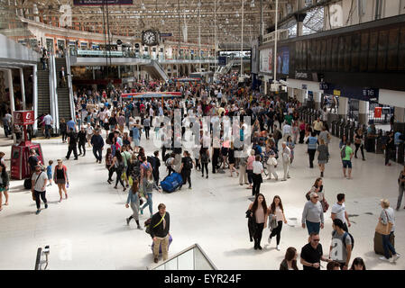 Passengers mingle on a busy London station concourse Stock Photo