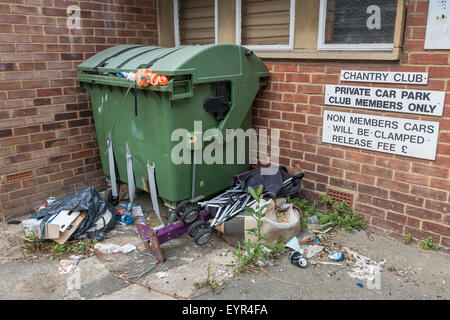 Overflowing rubbish dumped outside wheelie bin Stock Photo