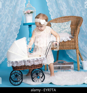 little girl playing with dolls and stroller Stock Photo