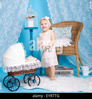 little girl playing with dolls and stroller Stock Photo