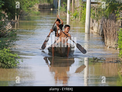 Magway Region, Myanmar. 3rd Aug, 2015. Children paddle their boat in a flooded area at Minbu district in Magway region, Myanmar, on Aug. 3, 2015. Heavy monsoon rains have left at least 47 people dead and affected more than 210,000 others in 12 out of Myanmar's 14 states and regions since June, the Ministry of Social Welfare, Relief and Resettlement said on Monday. Credit:  Kyaw Zaya/Xinhua/Alamy Live News Stock Photo