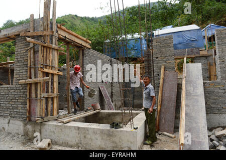 Ludian, July 30. 3rd Aug, 2014. Sixty-four-year-old Xie Weili (R) introduces his new house under construction in Longquan Community of Ludian County, southwest China's Yunnan Province, July 30, 2015. A 6.5-magnitude earthquake jolted Ludian County in Yunnan on Aug. 3, 2014. As one year has passed, the post-disaster reconstruction has been pushing forward orderly. © Hu Chao/Xinhua/Alamy Live News Stock Photo