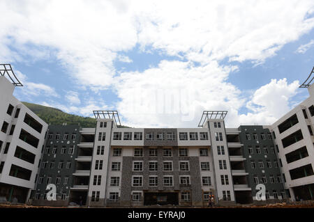 Ludian, China. 3rd Aug, 2015. The construction of a teaching building for Longquan Middel School is almost finished with interior decoration undergoing in Longtoushan Town of Ludian County, southwest China's Yunnan Province, July 30, 2015. A 6.5-magnitude earthquake jolted Ludian County in Yunnan on Aug. 3, 2014. As one year has passed, the post-disaster reconstruction has been pushing forward orderly. © Hu Chao/Xinhua/Alamy Live News Stock Photo