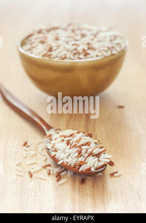 Rice berry, Brown rice and in wooden spoon and bowl on wood Stock Photo