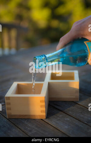 Pouring High End Sake in to Traditional Wooden Cups Stock Photo