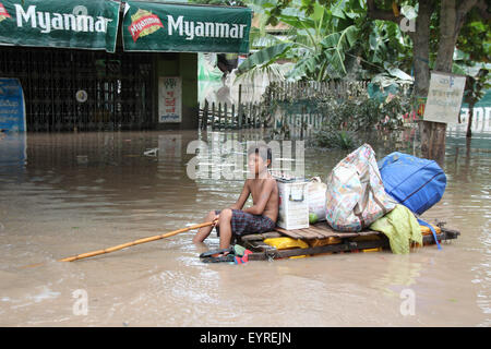 Kalay, Myanmar. 3rd Aug, 2015. A boy on a makeshift raft paddles his way through a flooded area in Kalay township of Sagaing Region, Myanmar, Aug. 3, 2015. Heavy monsoon rains have left at least 47 people dead and affected more than 210,000 others in 12 out of Myanmar's 14 states and regions since June, the Ministry of Social Welfare, Relief and Resettlement said on Monday. Credit:  Ko Thaung/Xinhua/Alamy Live News Stock Photo