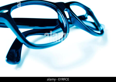 closeup of a pair of black plastic-rimmed eyeglasses on a white surface Stock Photo