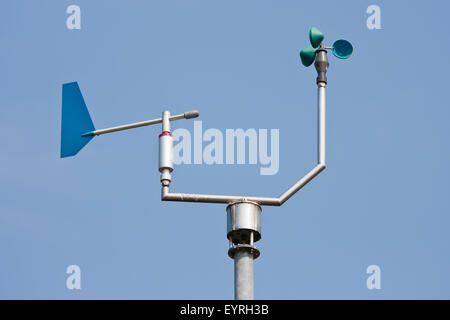 Anemometer measuring wind speed and direction with a blue sky in the background Stock Photo