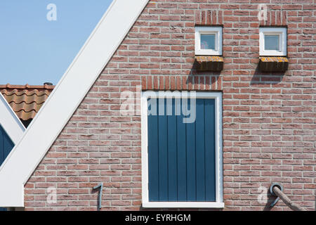 Wall with a big shutter and two small windows Stock Photo