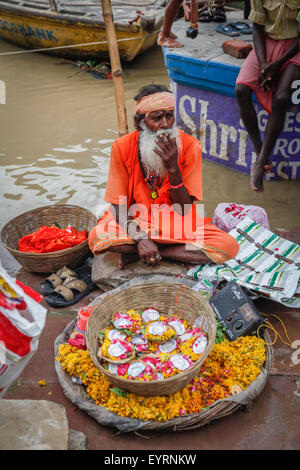 Sadu selling flowers at Dashashwamedh Ghat. Stock Photo