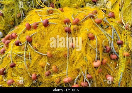 Yellow fishing nets piled up in a Greek Harbour. Stock Photo