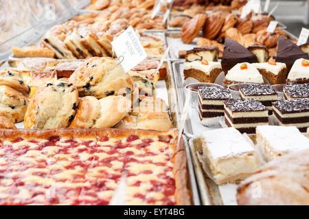 Assortment of many pastries and desserts displayed on bakery trays Stock Photo