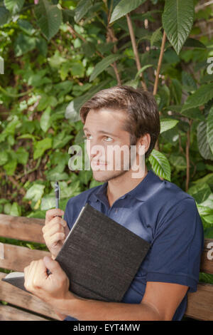 Man writing in a journal Stock Photo