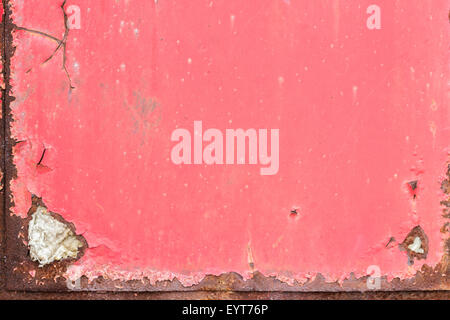 Close-up of a rusty, dirty and ragged metal door painted in red Stock Photo
