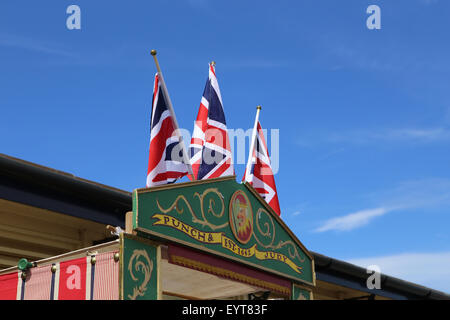 A sign  and Union flags above a traditional Punch and Judy show booth, on a seaside pier. Stock Photo