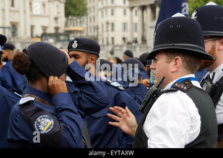 London, UK. 03rd Aug, 2015. A Metropolitan Police Officer (right) checks the beret of a Volunteer Cadet (left) at a parade in Trafalgar Square, London. The event to pay thanks to the Cadets was the first of its kind on 3rd August 2015. Credit:  Paul Grove/Alamy Live News Stock Photo