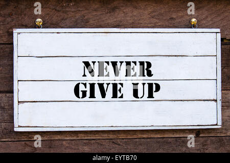 Never Give Up Inspirational message written on vintage wooden board. Motivation concept image Stock Photo