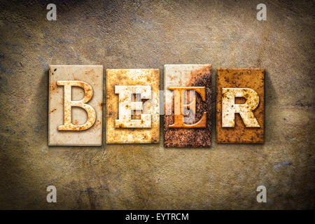 The word 'BEER' written in rusty metal letterpress type on an old aged leather background. Stock Photo