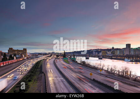 Portland Oregon rush hour traffic with city skyline along Interstate freeway during sunset evening Stock Photo