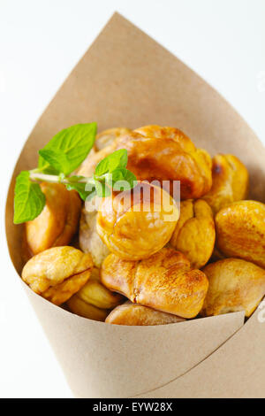 Peeled roasted chestnuts in a paper cone Stock Photo