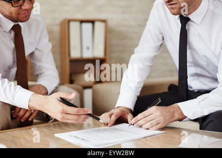 Two employees discussing contract at meeting Stock Photo