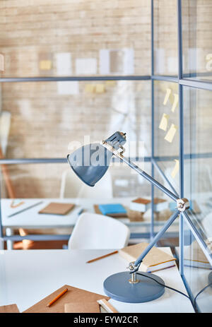 Lamp, book, notepad and pencils on desk Stock Photo