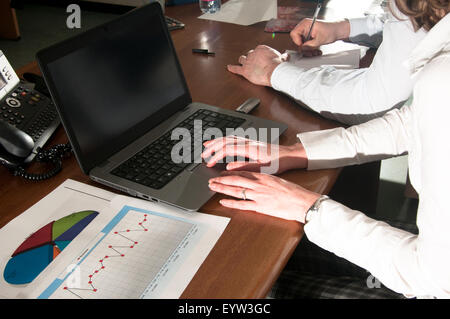 man and woman executives working on laptop. Stock Photo