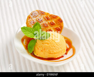 Small Dutch oval-shaped cake (Roomboter kano) with ice cream and caramel syrup Stock Photo