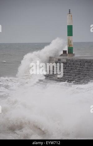 Aberystwyth Wales UK, Tuesday 04 August 2015 UK weather: The poor summer weather continues as gale force 6 winds and a high tide combine to drive waves crashing into the promenade in Aberystwyth on the west wales coast UK. The Met Office has put out a warning as the low pressure system off to the west of the UK is causing big waves affecting western areas through the day. The Royal National Lifeboat Institution (RNLI) is urging people to take care as they visit the coasts on their summer holidays. photo Credit:  Keith Morris/Alamy Live News Stock Photo