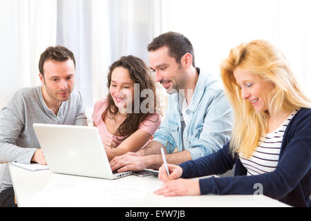 View of a Group of 4 young attractive people working on a laptop Stock Photo