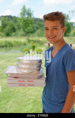 Boy holding cardboard boxes with pizzas, delivery service, Bavaria, Germany Stock Photo