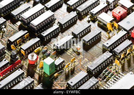 rows of electrical components arranged neatly on computer circuit board almost like a factory or industrial housing estate Stock Photo