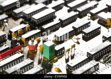 rows of electrical components arranged neatly on computer circuit board almost like a factory or industrial housing estate Stock Photo