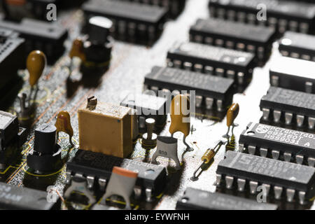 rows of electrical components arranged neatly on computer circuit board almost like a factory or industrial housing estate Stock Photo