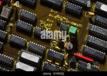 rows of electrical components arranged neatly on computer circuit board almost like a factory or industrial housing estate Stock Photo