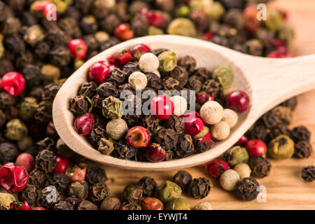 Pepper seeds in wooden spoon on wood table Stock Photo