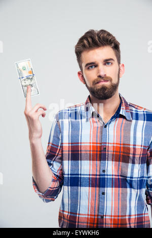 Portrait of a handsome man holding bill of USA dollar isolated on a white background and looking at camera Stock Photo