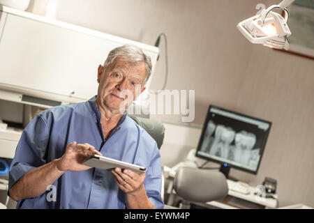 Dentist using digital tablet in office Stock Photo