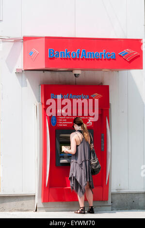 Woman using a cash machine in the wall of a Bank of America bank in Seattle. Stock Photo