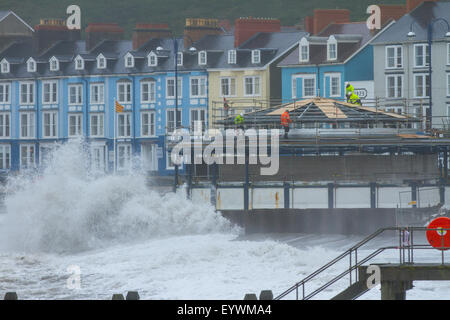 Aberystwyth, Wales, UK. 4 August 2015. Stormy Weather. A 5-8 ft swell, high winds and a high tide combine to lash Aberystwyth seafront with huge waves, as workmen continue work on the seafront's redeveloped bandstand Credit:  Alan Hale/Alamy Live News Stock Photo