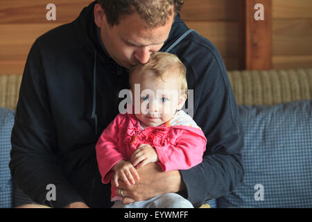 Man sitting with his daughter on a couch Stock Photo