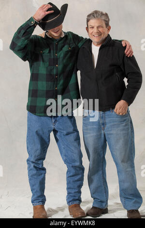 Young man with autism adjusting his hat and his mentor arm in arm Stock Photo