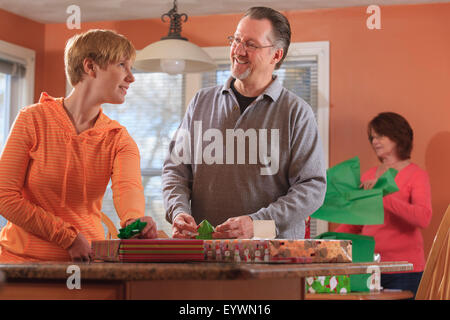 Young woman with visual impairment and right sided Cerebral Palsy working on Christmas packages with her parents Stock Photo