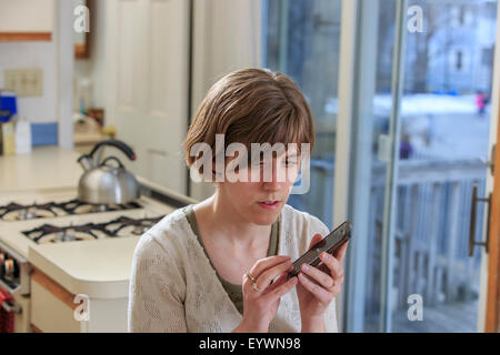 Blind woman using assistive technology to listen to her cell phone Stock Photo